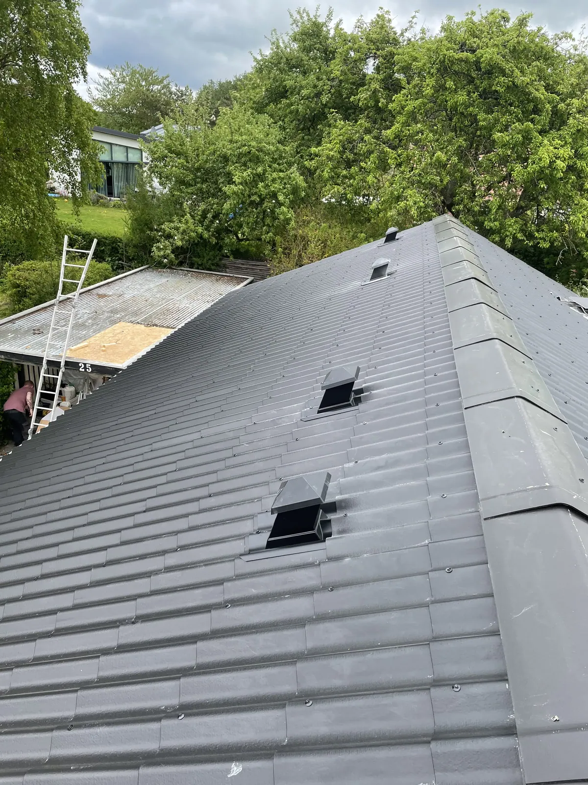 Nyt tag under montage på skrå tagflade - tømrer fra Top Hansen ApS på stigen